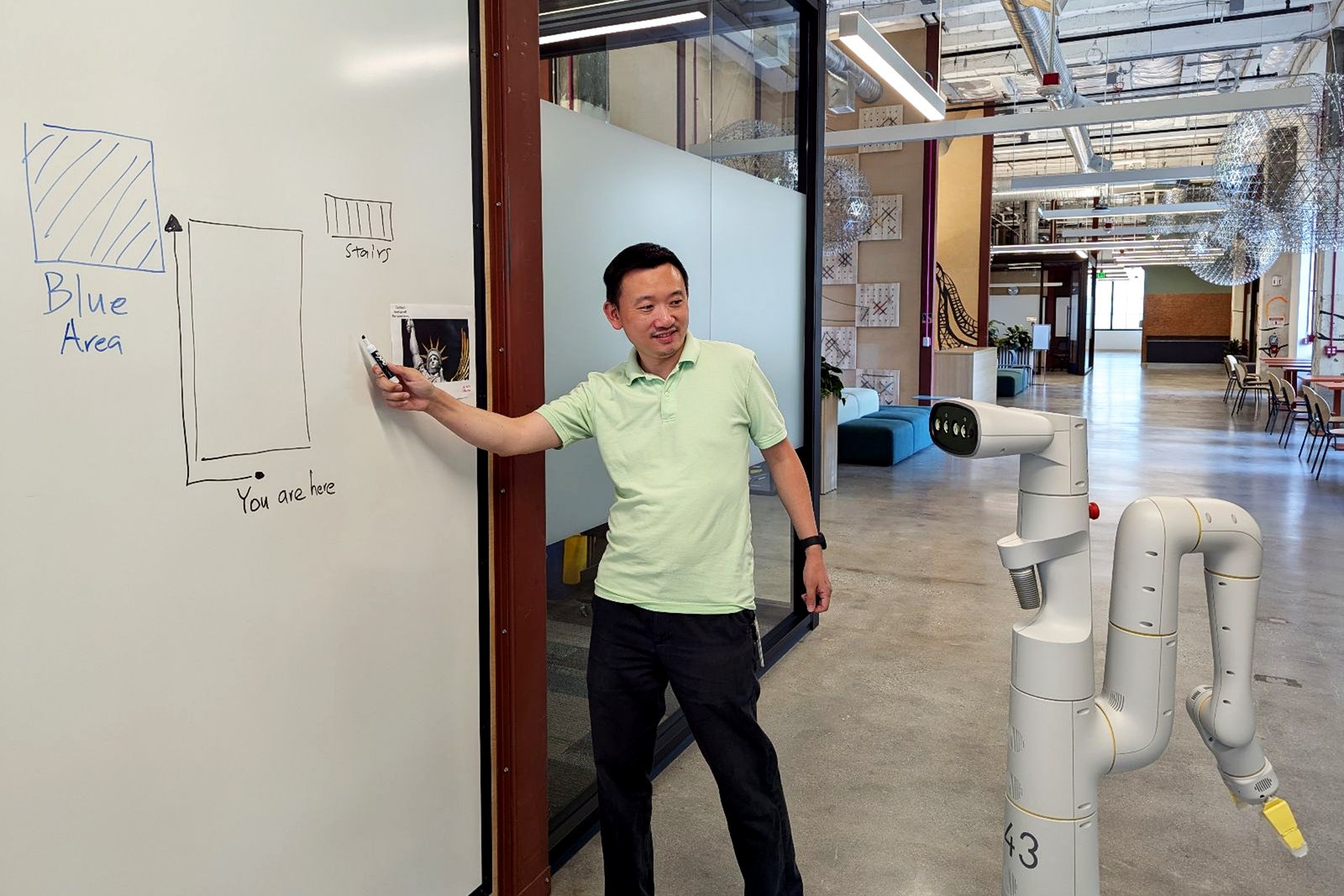 A photo of a Google DeepMind employee communicating with an AI robot.