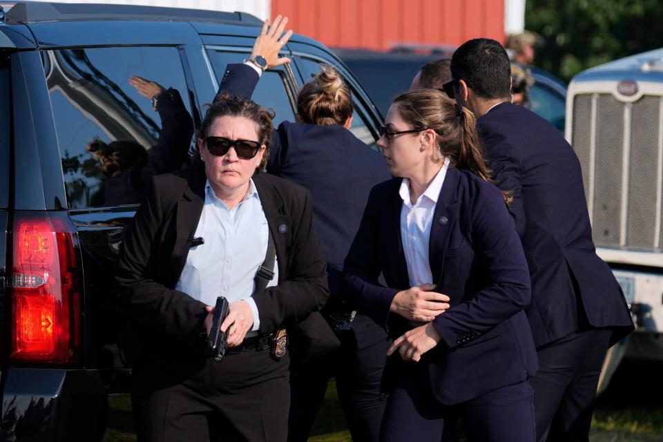 Secret Service agents surround Trump's SUV after escorting him to his vehicle.