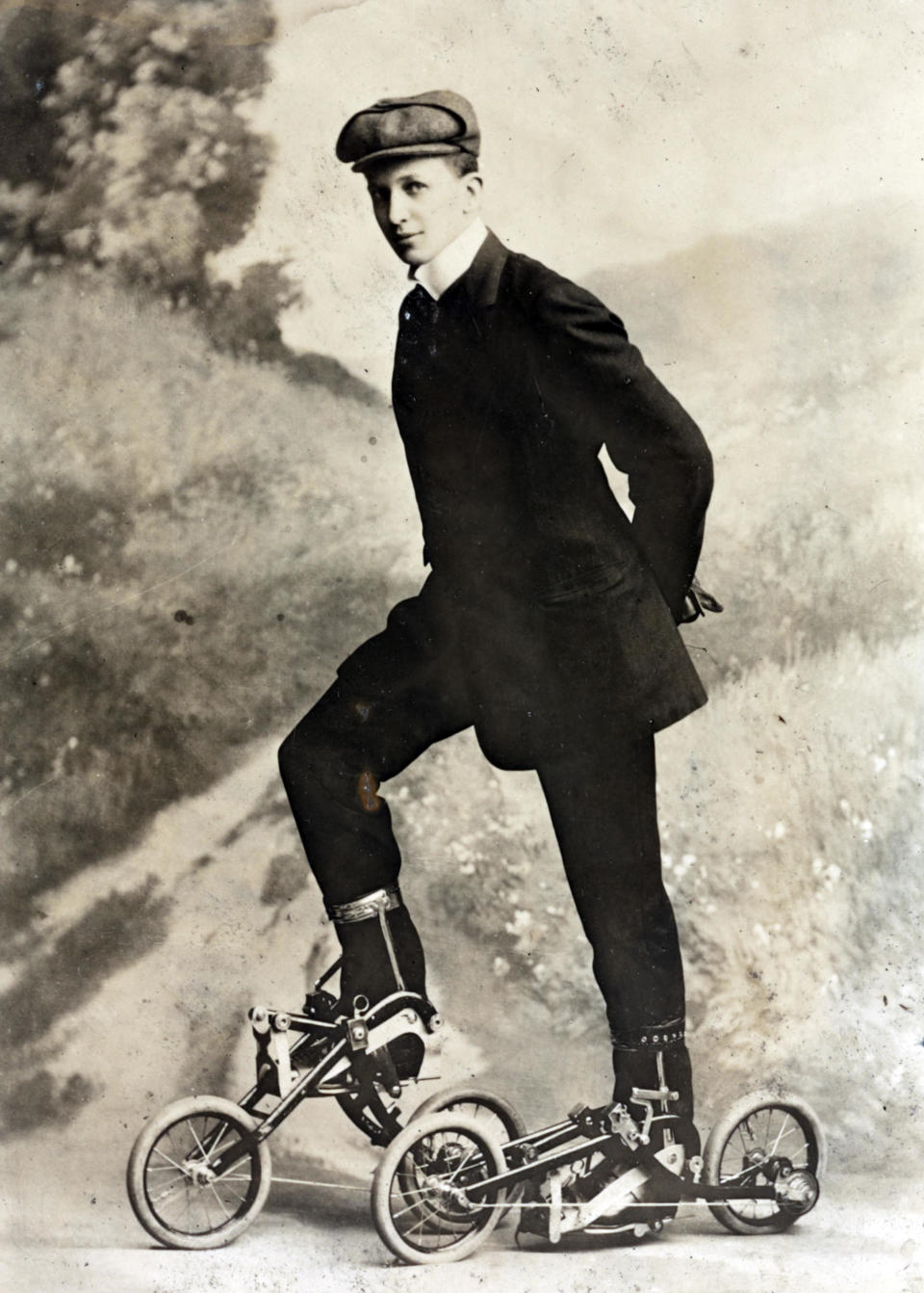 A vintage image of a person in early 20th century clothing and unconventional roller skates with wheels