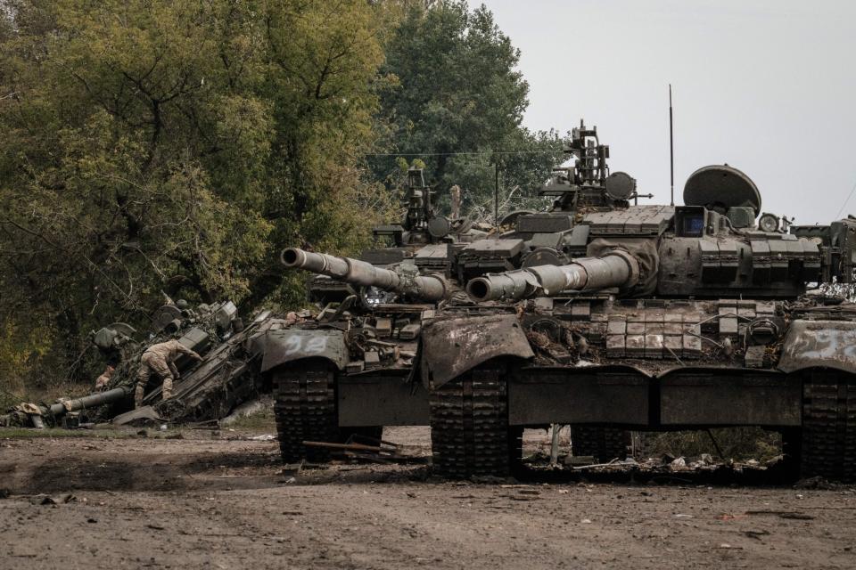 A Ukrainian soldier loots one of three abandoned Russian T-90M tanks.