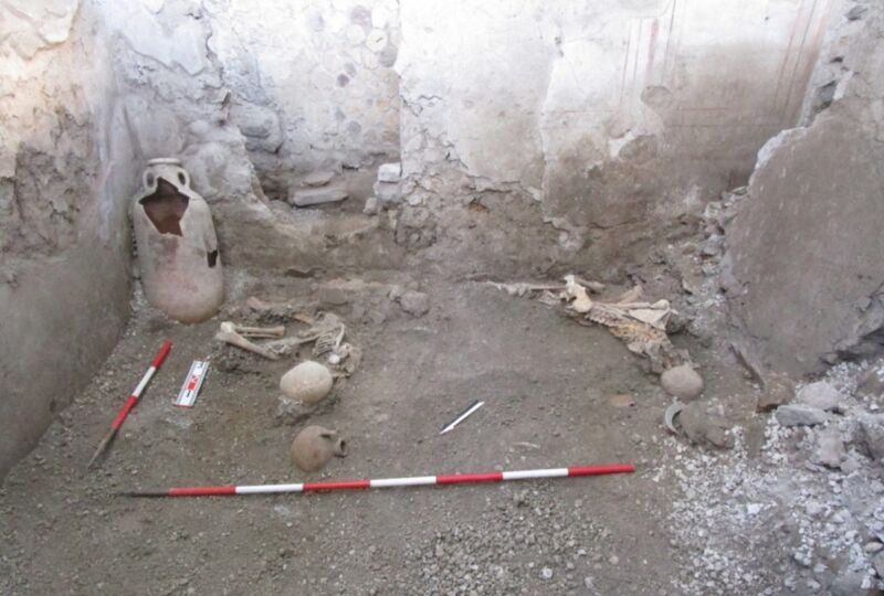 two skeletons in the rubble of an archaeological site in Pompeii