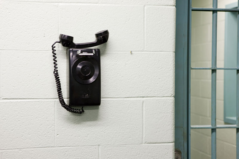 A telephone on the wall in a prison.