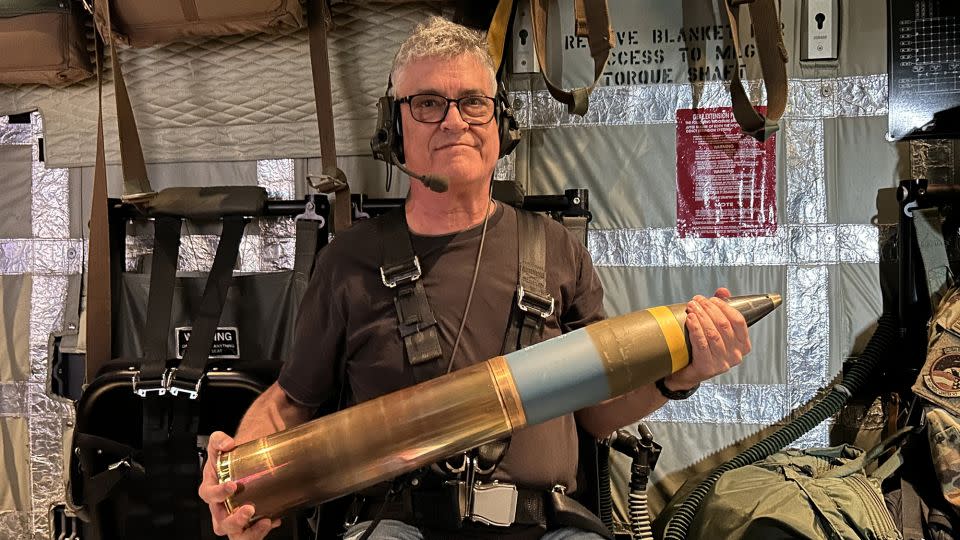 CNN senior global military affairs writer Brad Lendon holds a 105mm howitzer shell aboard a U.S. Air Force AC-130J fighter jet taking off from Osan Air Base in South Korea in June 2024 - Mike Valerio/CNN