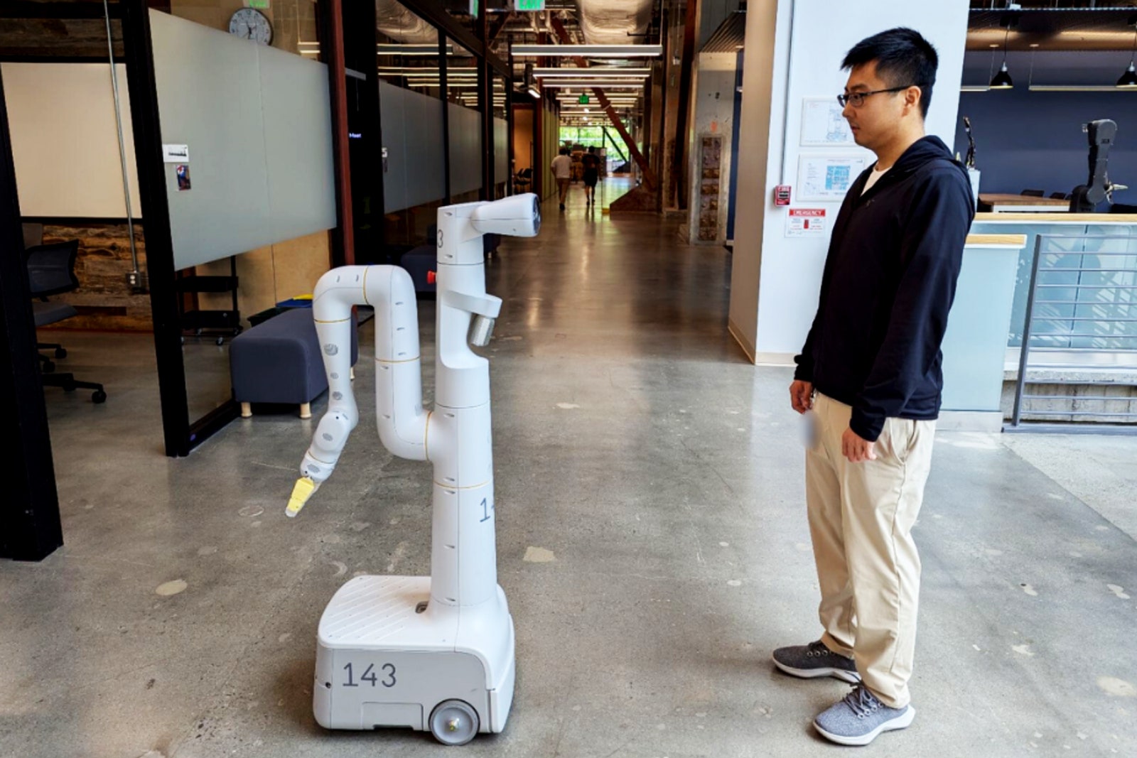 A photo of a Google DeepMind employee communicating with an AI robot.