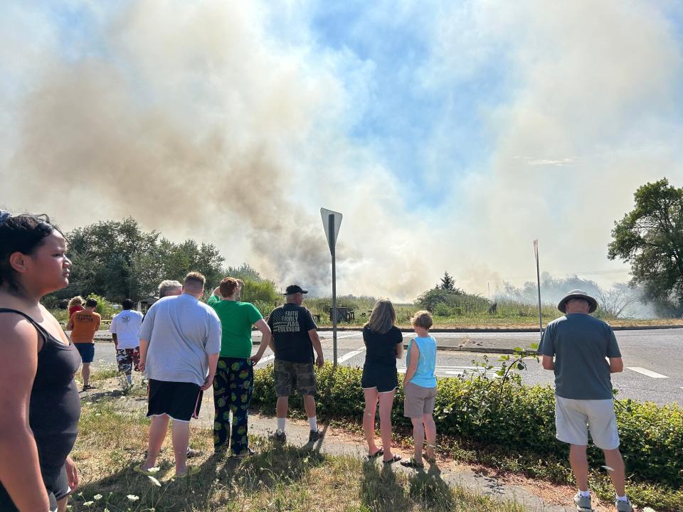 A crowd gathers at the scene of a reported fire south of the Eugene airport Monday afternoon.