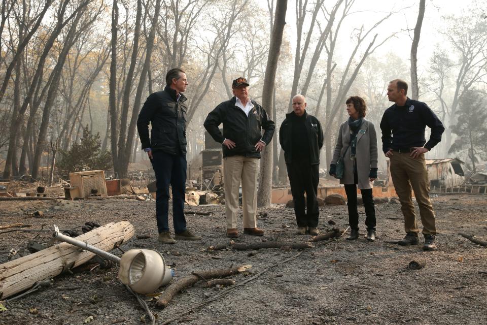 President Donald Trump visits the charred wreckage of Skyway Villa Mobile Home and RV Park with Gov.-elect Gavin Newsom (left), FEMA chief Brock Long (right), Paradise Mayor Jody Jones (2nd from right) and Gov. Jerry Brown in Paradise, California on November 17, 2018.