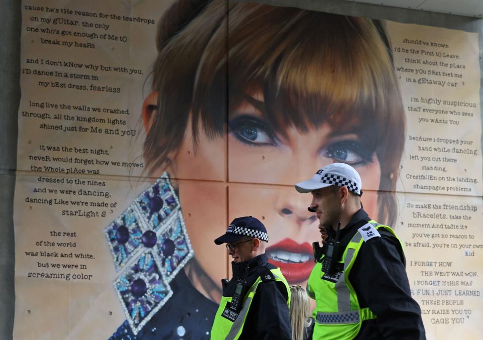 Police officers walk past a mural of Taylor Swift during their duty before the Community Shield football match at Wembley Stadium in London