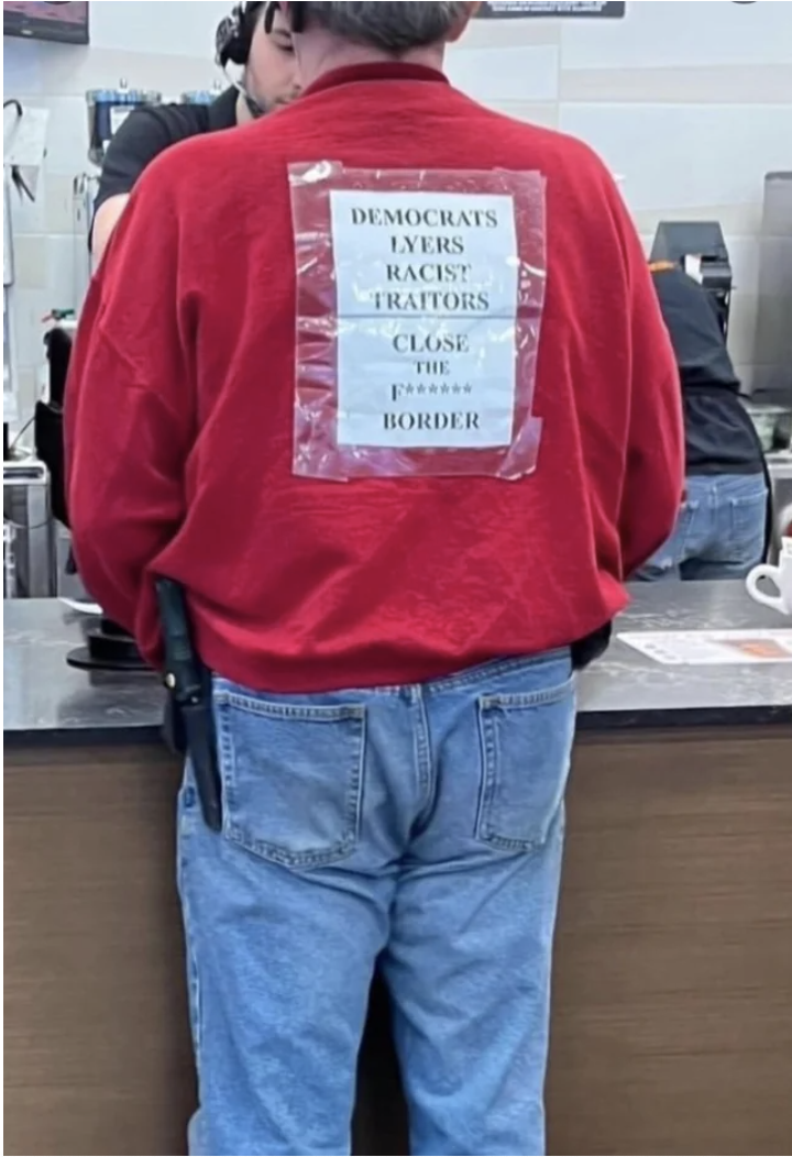 A man with a piece of paper stuck to his shirt