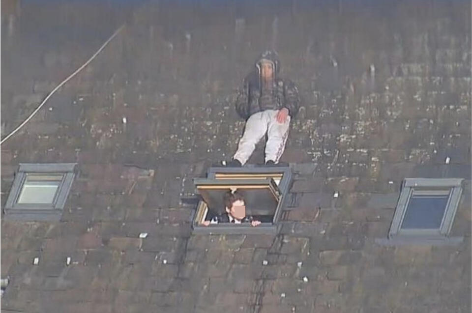 A man stands on a windowsill