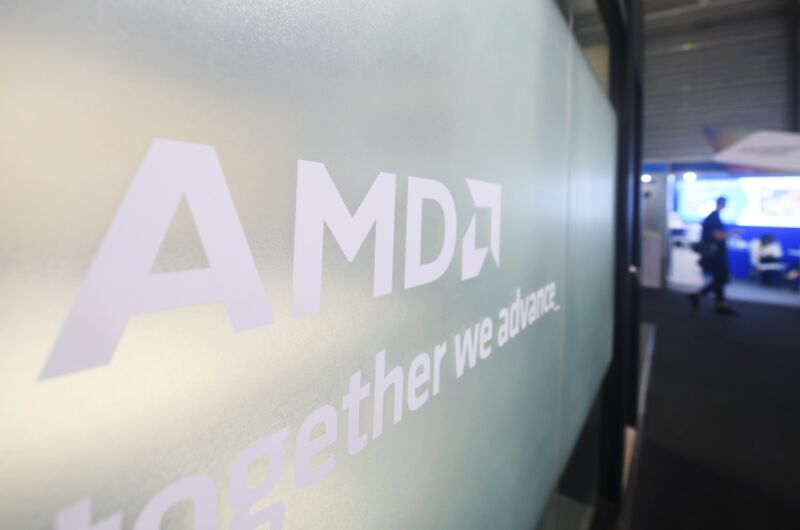 Visitors walk past the AMD booth at Mobile World Congress 2024