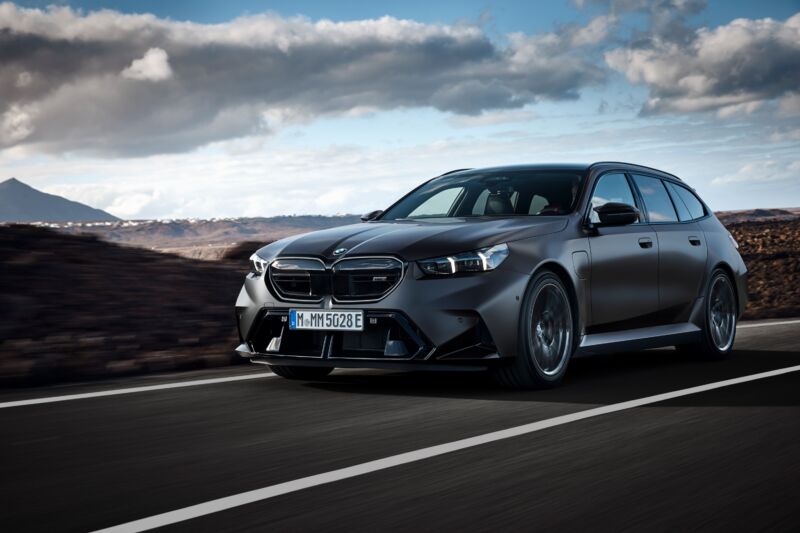 A BMW M5 Touring drives through a volcanic landscape