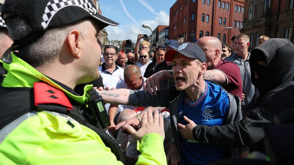 Protester shouts at police officer while surrounded by other protesters