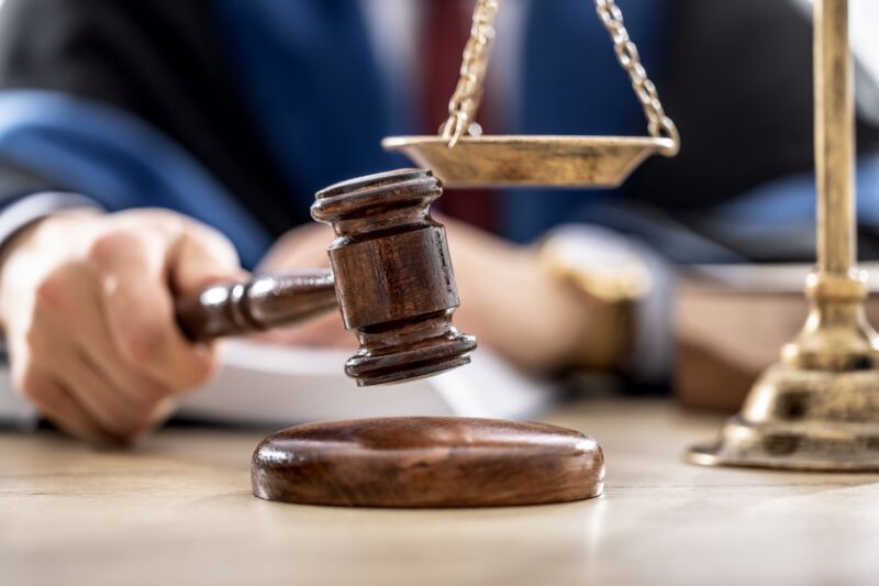 A judge striking a gavel next to a pair of scales, symbolizing justice