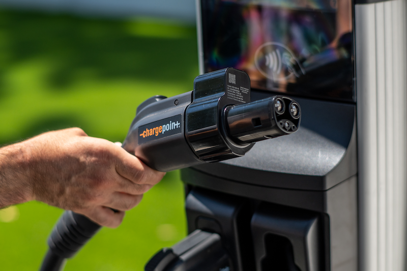 A person holds a charging plug for an electric car