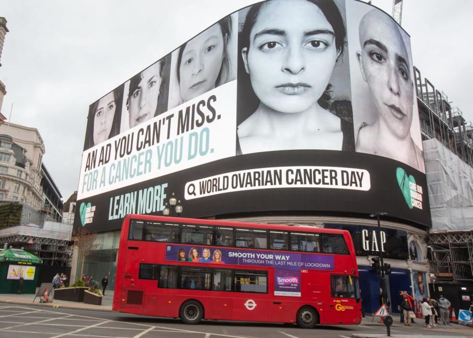 The author, second from left, stood on a billboard in London's Piccadilly Circus on World Ovarian Cancer Day 2021, alongside others sharing her diagnosis of low-grade serous ovarian cancer