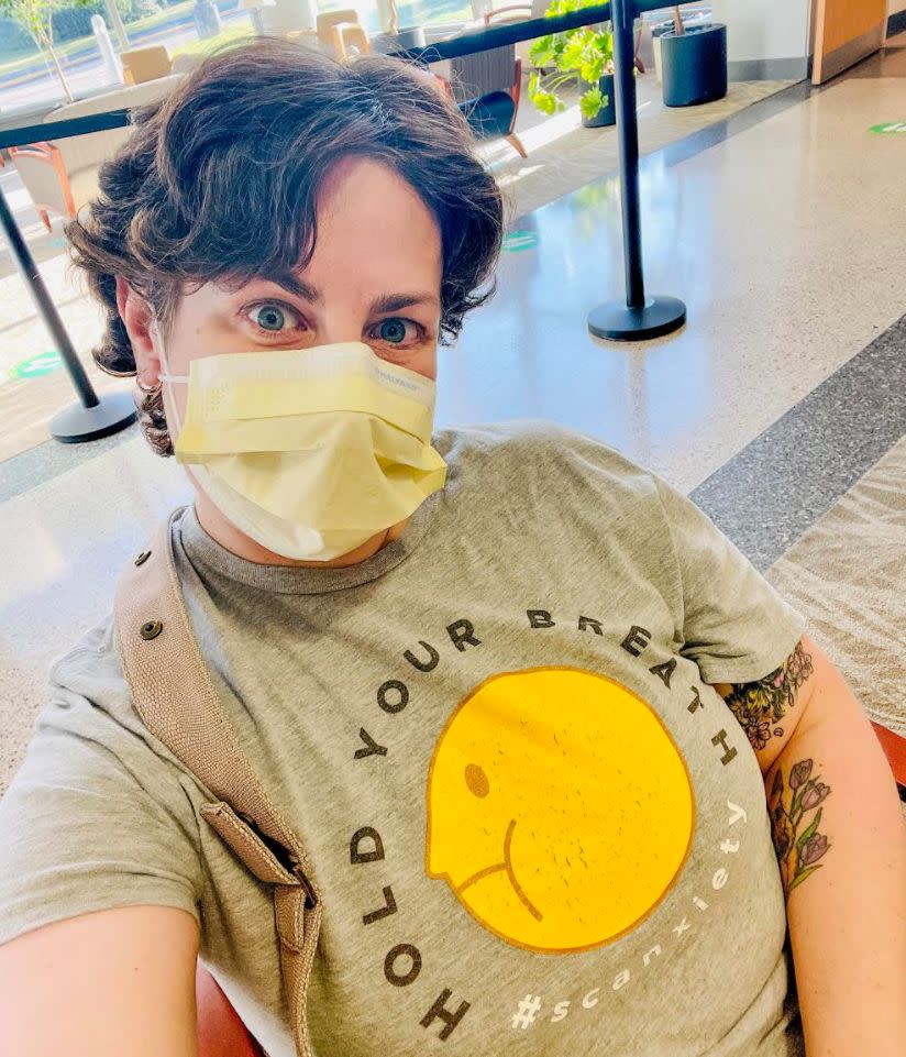 Nearly a year after completing chemotherapy, the author waits in the hospital lobby, masked and alone, as she did during most of her cancer treatment