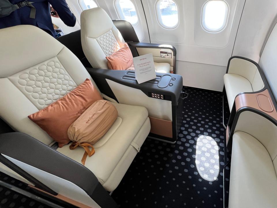 Two seats in the front of Beend's A319 in cream-colored leather, with footstools