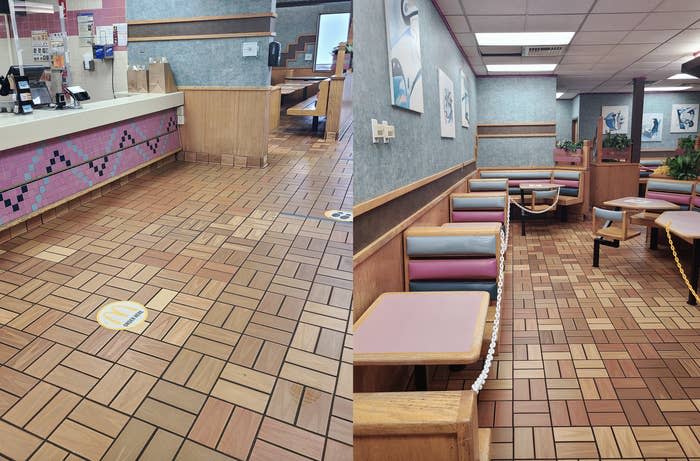 Empty fast food restaurant interior with tiled floor, booths and social distancing markings on the floor. No people present