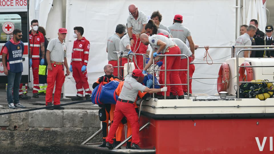 Rescue workers carry a body as divers return to the port of Porticello near Palermo, three days after the British-flagged luxury yacht Bayesian sank. - Alberto Pizzoli/AFP/Getty Images