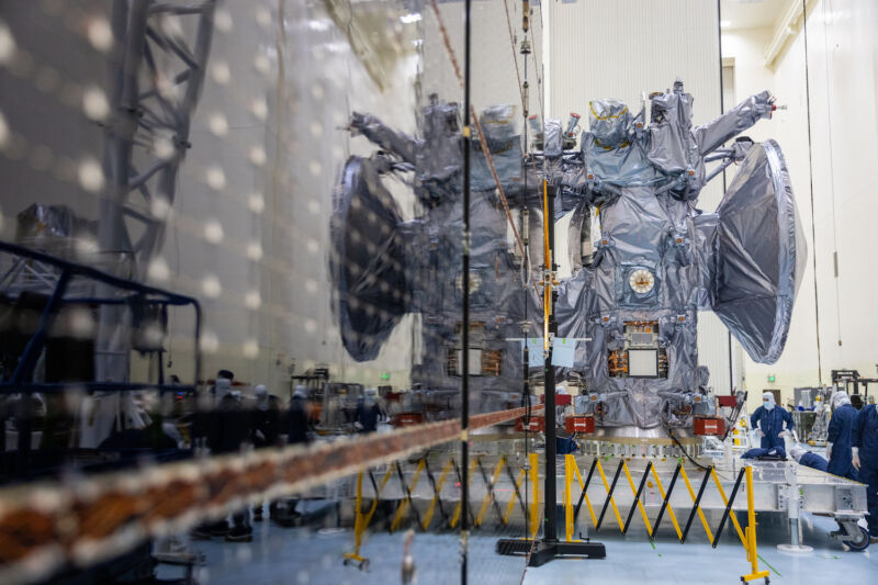 The main body of NASA's Europa Clipper spacecraft is reflected in one of the mission's deployable solar panels during a test at the Kennedy Space Center in Florida.