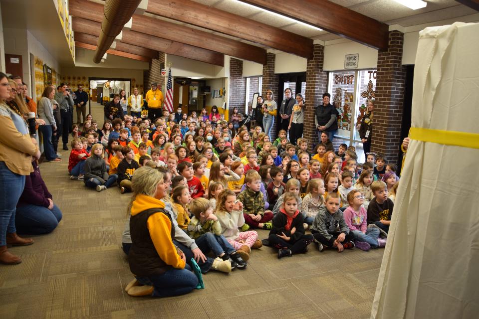 Students at Pellston Elementary School gather for the unveiling of a book vending machine in February 2024.