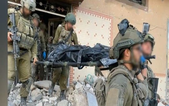 IDF troops carry Yahya Sinwar's body from a building in Rafah