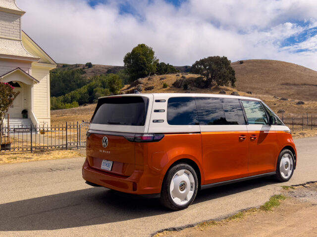 A VW ID Buzz parked next to a small church in a rural Californian town.