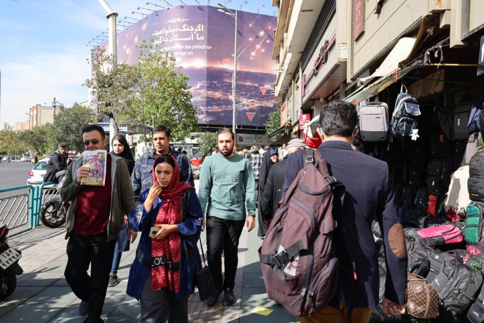 People walk through a street in Tehran on October 26, 2024. Residents of Tehran woke up and went about their business on October 26 after their sleep was disrupted by Israeli attacks that set off explosions that reverberated through the city (AFP via Getty Images)