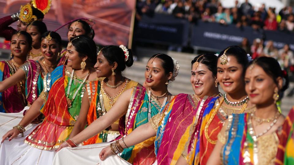 Dancers hold up their multi-colored saris in a line during the celebration of Diwali on the Square