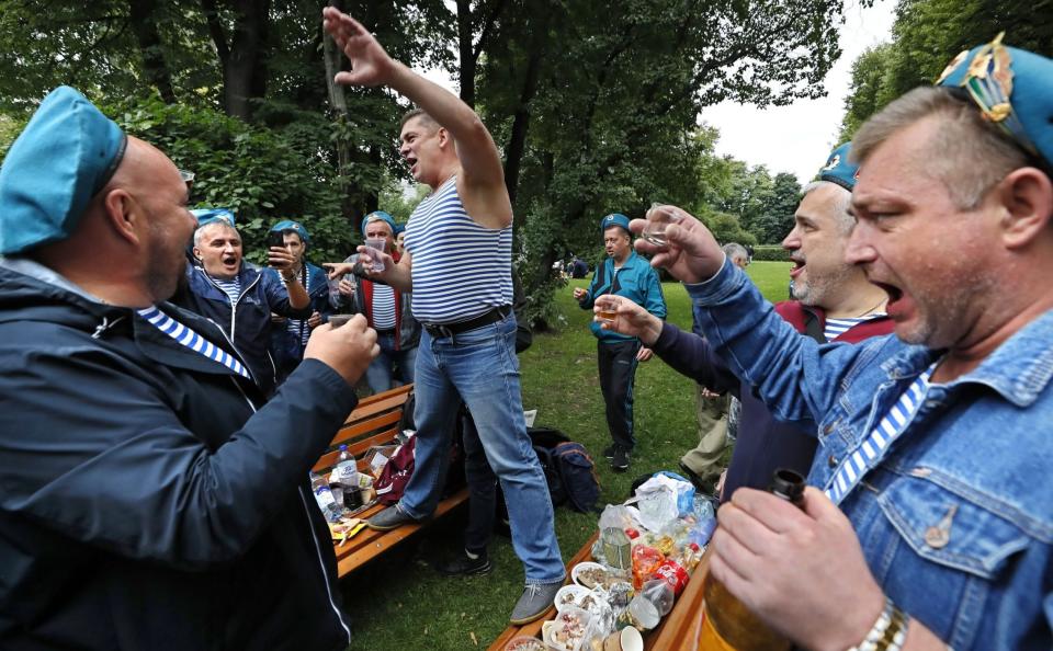 Russian former paratroopers drink vodka during Parachute Day celebrations in Gorky Park in Moscow