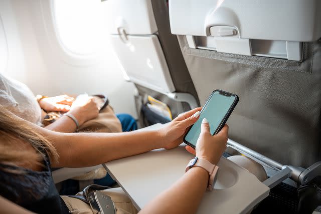 Jorge Aguado Martin/Getty Stock Image A person uses his phone on a plane