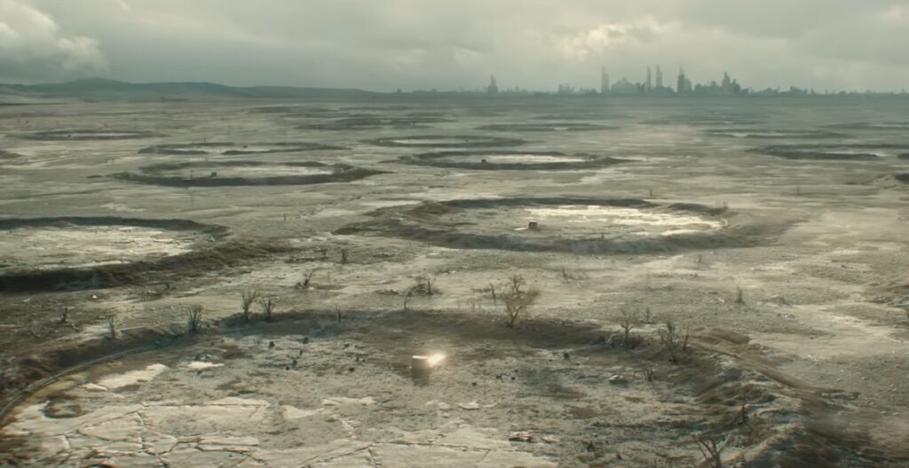 widescreen view of the desolate, barren, flat landscape against the gray-green sky