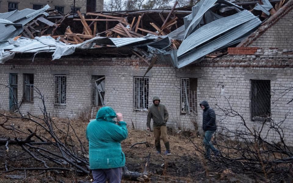 People investigate the damage caused by the Russian attack on Dnipro