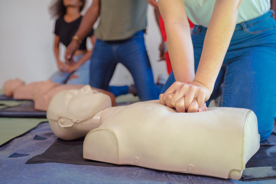 People practice CPR on mannequins during a training session