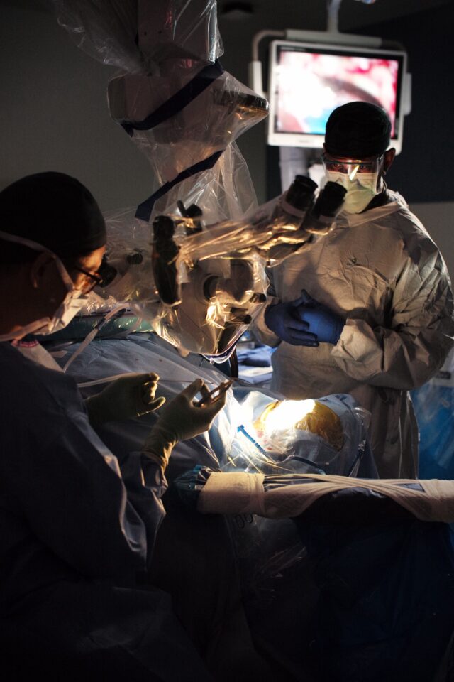 surgeons operating on a patient's brain