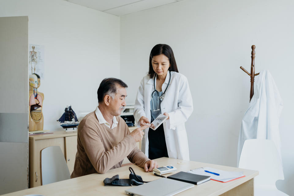 Doctor showing a document to a patient in a clinic office