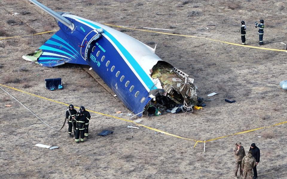 A drone shot shows emergency specialists working at the crash site of an Azerbaijan Airlines passenger plane