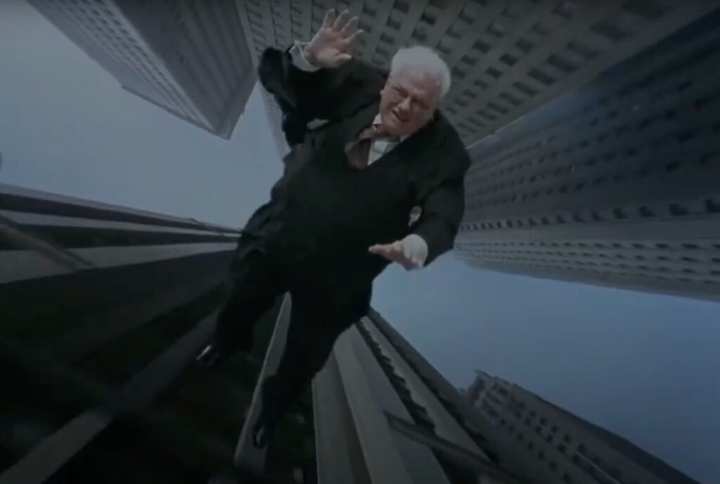 white-haired man in suit in mid-air, falling from a skyscraper