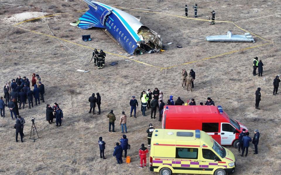 Emergency specialists work at the crash site of a passenger plane near Aktau