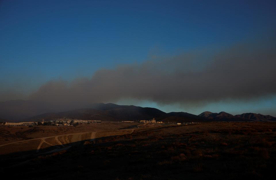 Smoke rises as firefighters battle the Border 2 fire next to the Mexican border, in the hills east of the Otay Mesa neighborhood of San Diego, California on January 23, 2025.