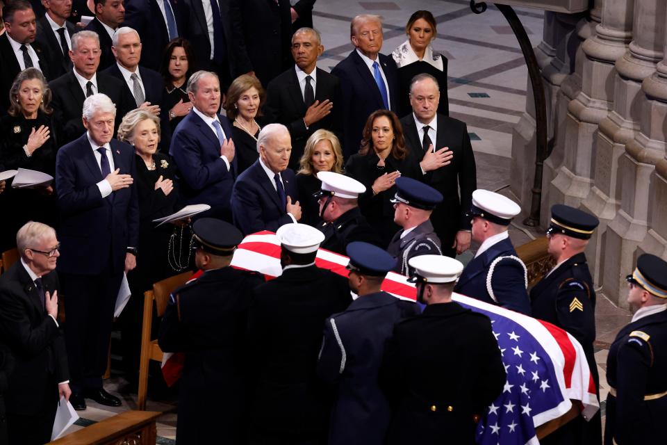 U.S. Army pallbearers carry the flag-draped casket containing Jimmy Carter's remains from the Washington National Cathedral during his state funeral as Donald Trump, Joe Biden, Kamala Harris and many others look on January 9, 2025 in Washington, DC.