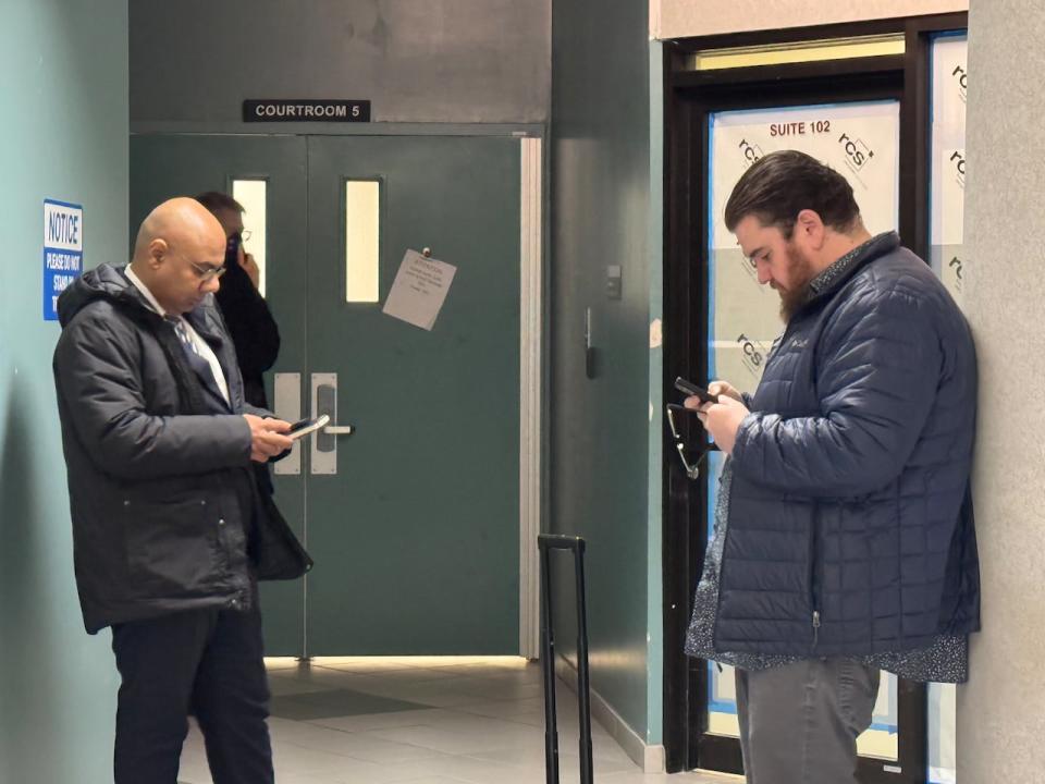 Conor Dolan, right, awaits his sentence outside a courtroom in Dartmouth, N.S. He pleaded guilty to distributing intimate images without consent.  