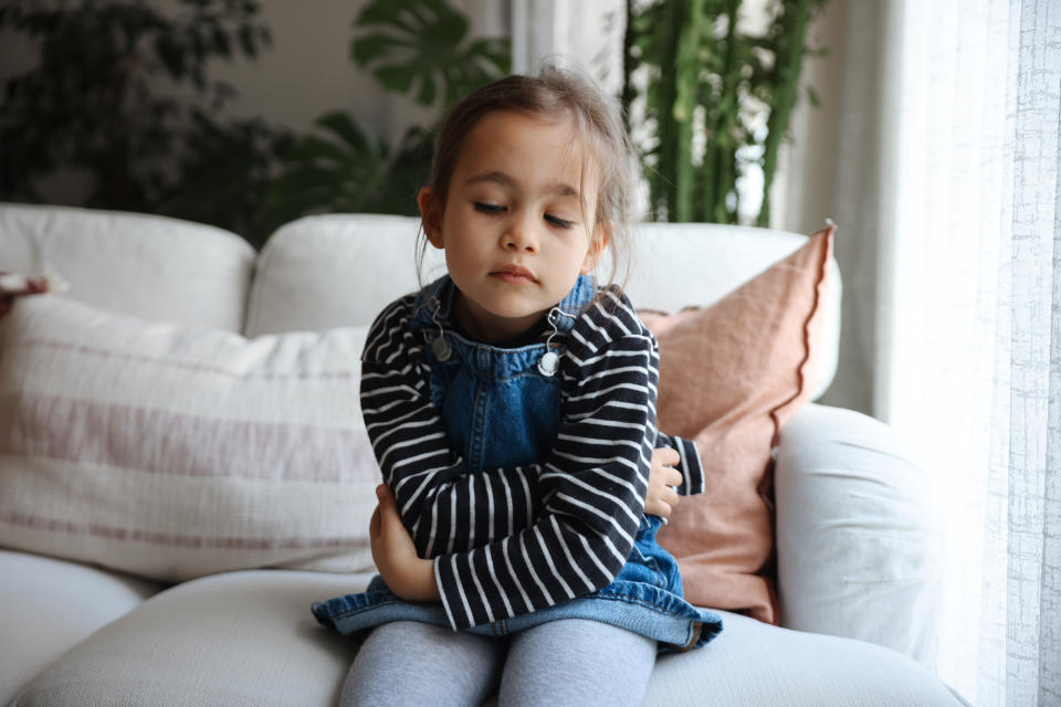 Photo of the young girl with stomach pain. 