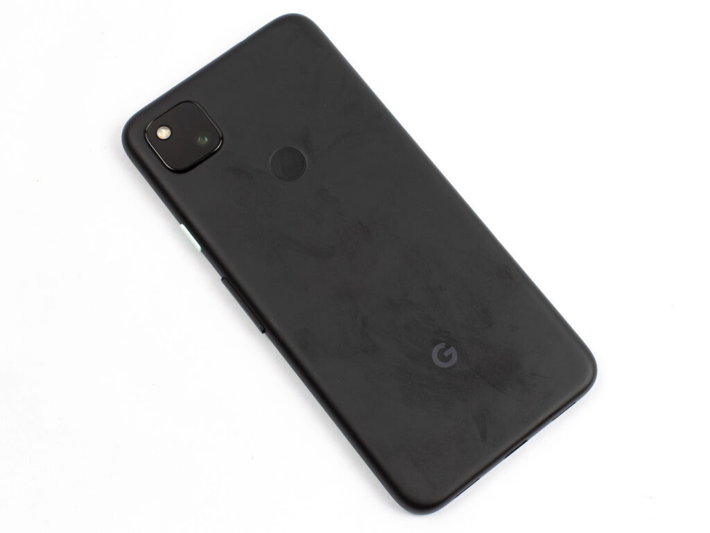 Pixel 4A, tilted, with careful, with fingerprints over the back.