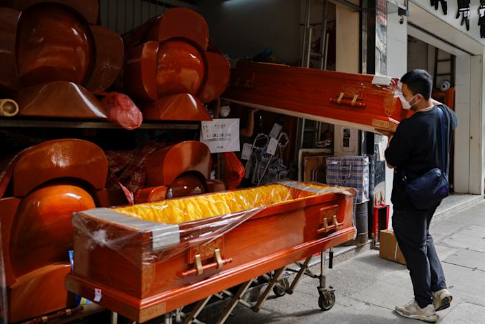 Workers move coffins.