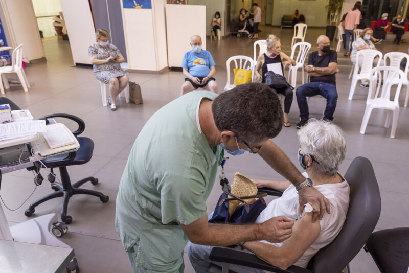 A health worker administers a third dose of the Pfizer-BioNTech COVID-19 vaccine to an elderly resident of the Ichilov Medical Center in Tel Aviv, Israel, on Monday, August 2, 2021.