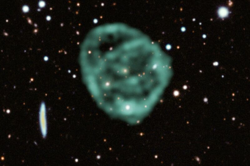 Data from SARAO's MeerKAT radio telescope data (green) showing the odd radio circles is superimposed over optical and near infrared data from the Dark Energy Survey. 