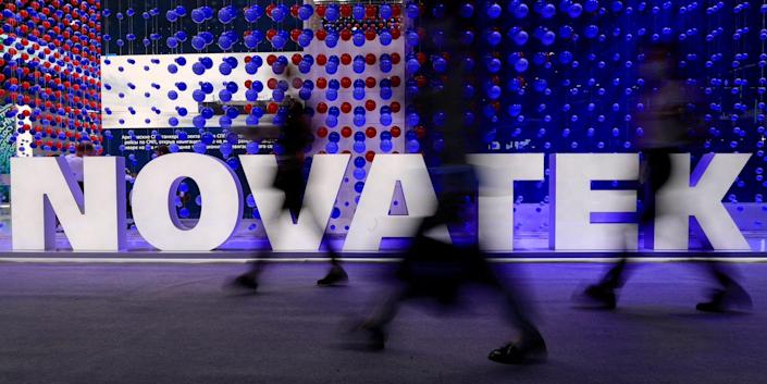 People walk past a sign that reads 'Novatek' at the St. Petersburg International Economic Forum in Russia, June 2, 2021