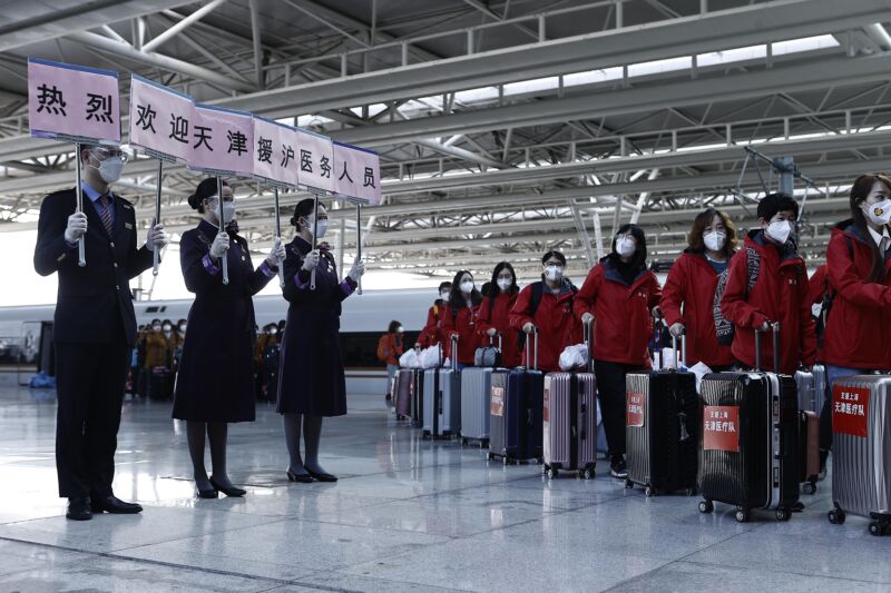 Train attendants with placards welcome a Tianjin medical team at the Shanghai Hongqiao Railway Station on April 3, 2022 in Tianjin, China.  A team of medical personnel from Tianjin arrived in Shanghai on Sunday to support the city's fight against the COVID-19 epidemic.