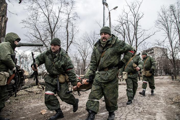 Soldiers of the DNR (Donetsk People's Republic) run with a stretcher with a wounded separatist in a disputed area of ​​Mariupol.  The battle between Russian/Pro-Russian forces and the defending Ukrainian forces led by the Azov Battalion continues in the port city of Mariupol.